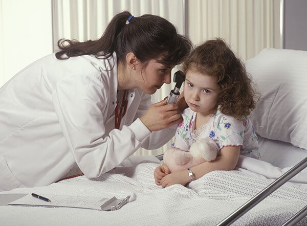 Doctor checking child's ear