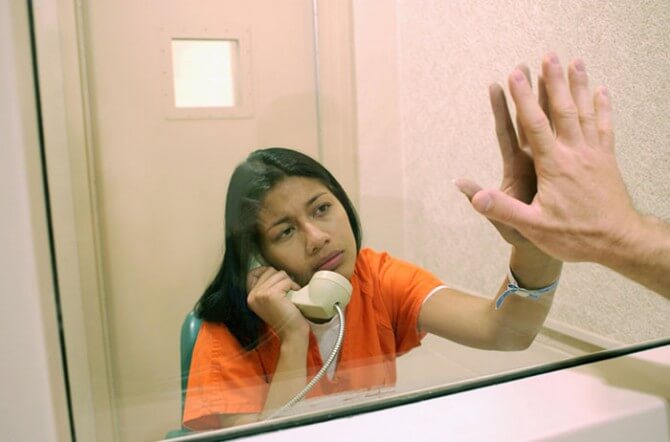Woman talking to someone behind bars