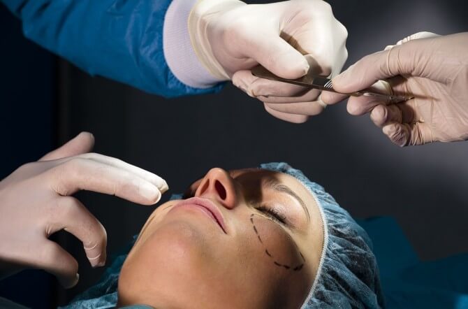 plastic surgeon with patient during surgery