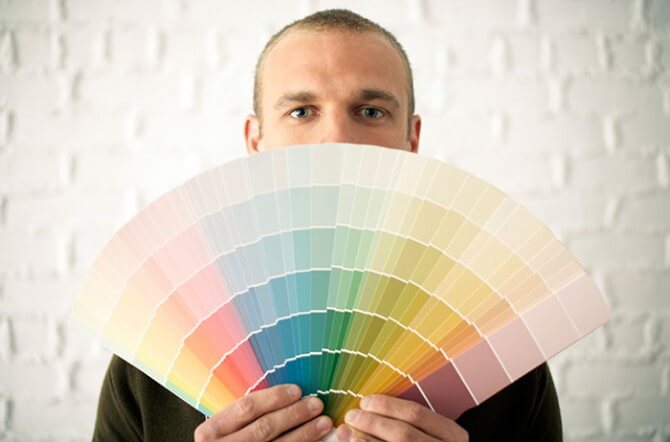 man holding paint color swatches
