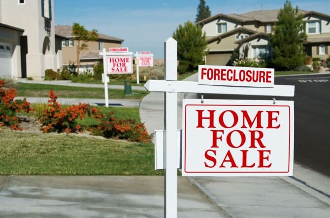 Row of homes with foreclosure signs