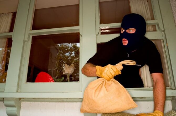 burglar leaning out of house window