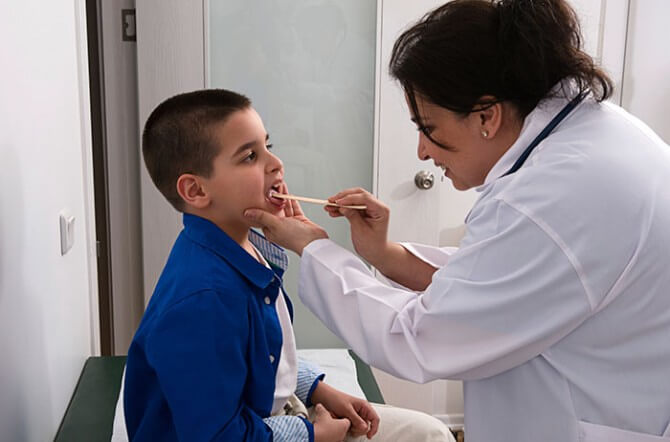 Doctor checking child's mouth