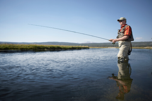Senior man flyfishing in river