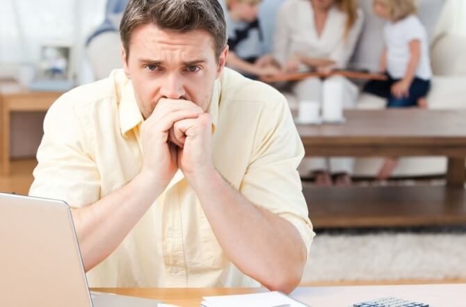 Father stressed over finances while family sits in background