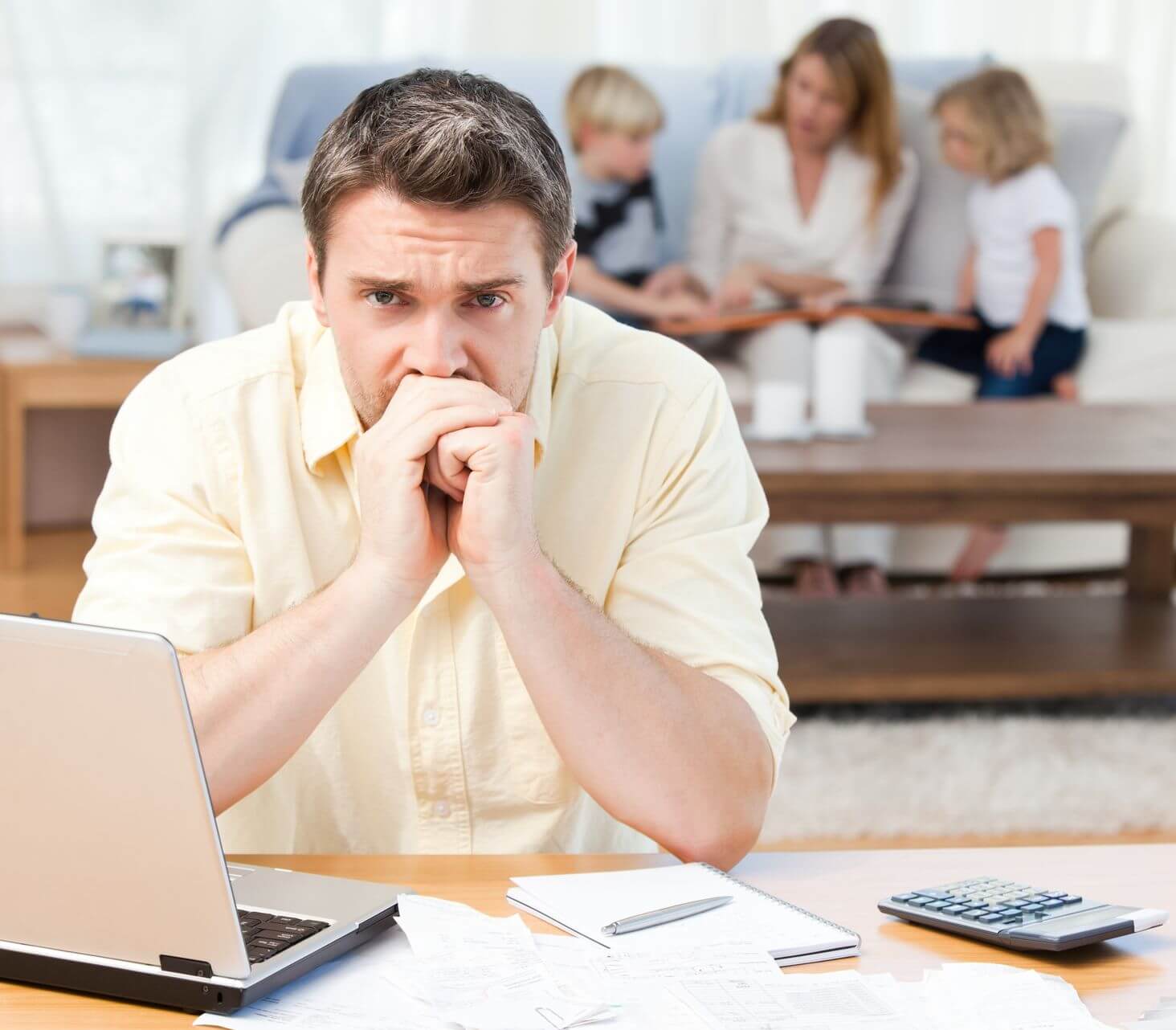 Father stressed over finances while family sits in background