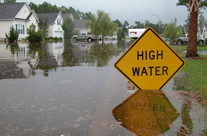 high water sign in flooded neighborhood