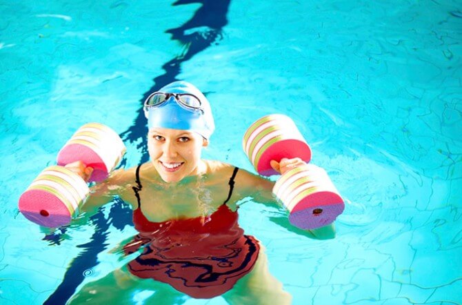 woman lifting weights in swimming pool