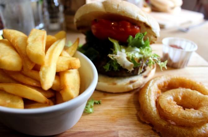 Image of gourmet burger, chunky chips, onion rings and salad