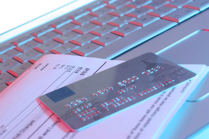 Close-up of a credit card with a bill on a laptop