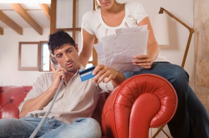 Couple with bills and credit card and telephone