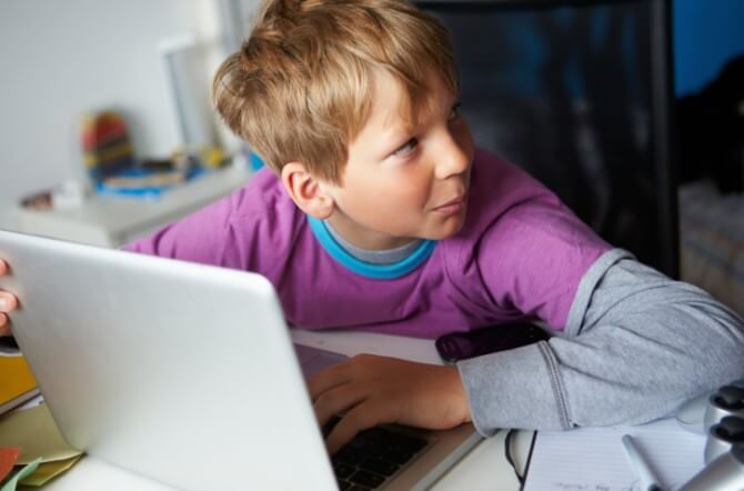 Boy Behaving Suspiciously Whilst Using Laptop
